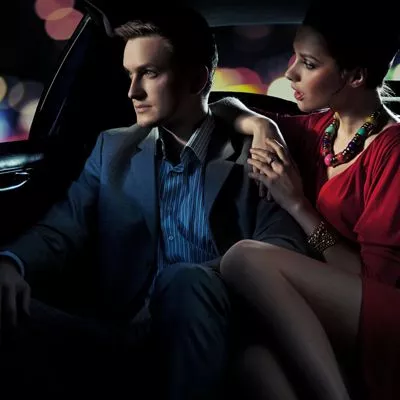 Couple sitting in the back of a limo enjoying a limo ride in New York City.
